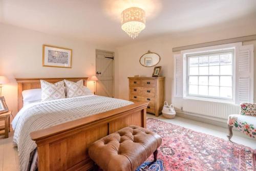 a bedroom with a bed and a chair and a window at Lantern Cottage in Stowmarket