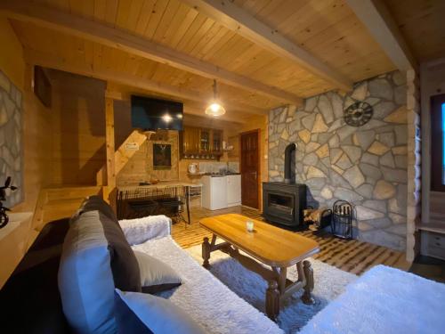 a living room with a couch and a stone wall at Ethno House Bektesevic in Gusinje