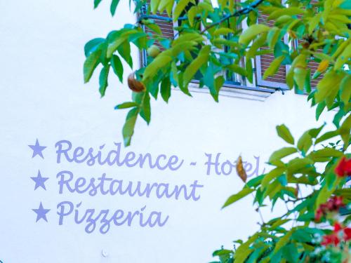 a sign hanging from a tree with fruit at Appartements Eppanerhof in Appiano sulla Strada del Vino