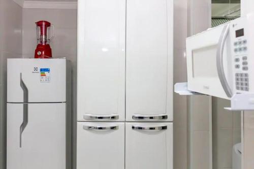 2 witte koelkasten in een keuken met een magnetron bij Apê 2 in Sao Paulo