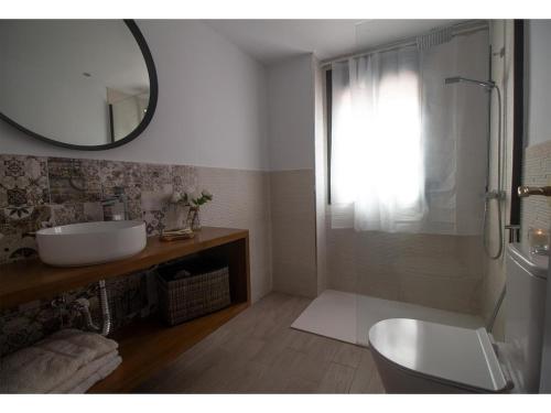 a bathroom with a sink and a toilet and a mirror at Lightbooking Ancora Cádiz in El Puerto de Santa María
