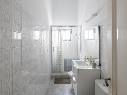 a white bathroom with a shower and a sink at Lightbooking Patio tipico canario Hermigua in Hermigua