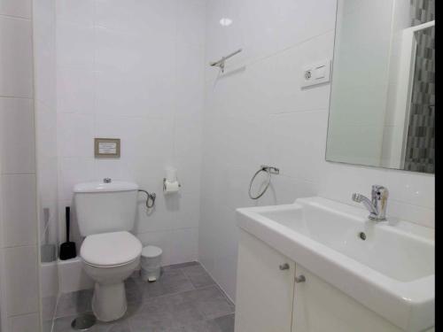 加的斯的住宿－Lightbooking Estadio Cádiz，白色的浴室设有卫生间和水槽。