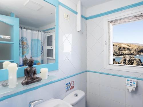 a bathroom with a toilet and a window at Lightbooking casa de playa Tenerife in Santa Cruz de Tenerife