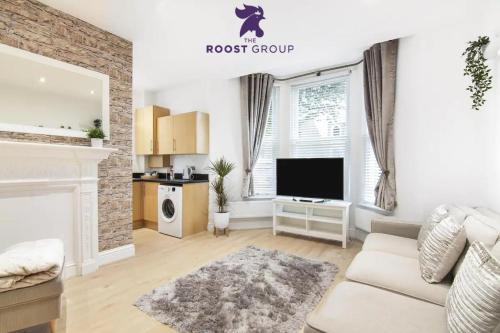 a living room with a couch and a tv at The Roost Group - Bedford House Apartments in Gravesend