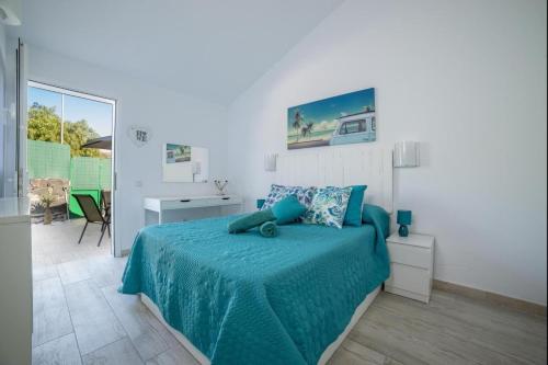 1 dormitorio con 1 cama con manta azul y escritorio en Lightbooking Aguila Beach San Agustin en Maspalomas
