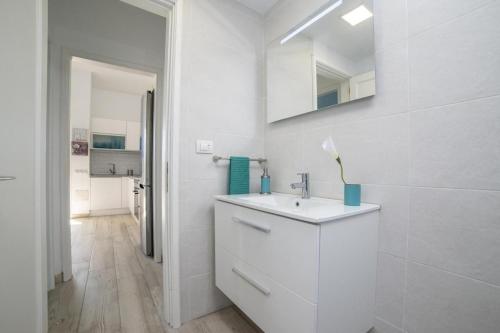 a white bathroom with a sink and a mirror at Lightbooking Aguila Beach San Agustin in Maspalomas