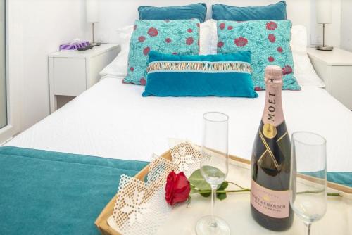 拉斯帕爾馬斯的住宿－Lightbooking Canteras Beach，睡床旁的桌子上放一瓶葡萄酒