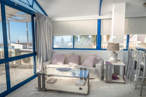 uma sala de estar com um sofá e uma mesa de vidro em Lightbooking Praia Fabrica Algarve em Vila Nova de Cacela