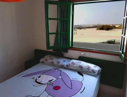 a bedroom with a bed with a pillow and a window at Lightbooking Los Lagos El Cotillo in Cotillo