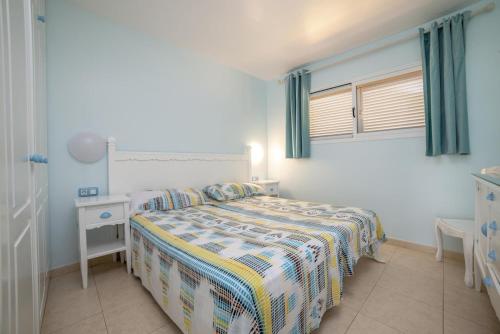 コラレホにあるLightbooking Oasis Royal Corralejoのベッドルーム1室(ベッド1台、テーブル、窓付)