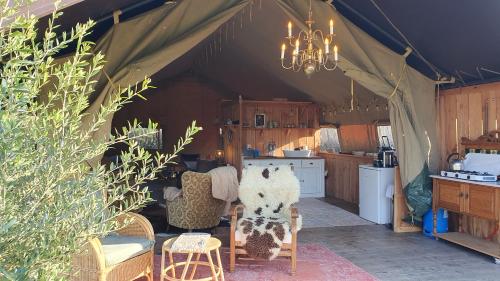 a room with a tent with chairs and a kitchen at Luxe tent op het platteland in Nieuwediep