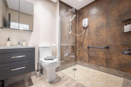 a bathroom with a shower and a toilet and a sink at Harbour View Apartment at Royale Court Apartments Portrush in Portrush