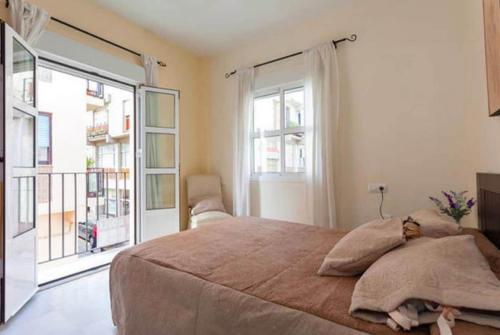 una camera con un grande letto e un balcone di Lightbooking Mazarredo San Fernando a San Fernando