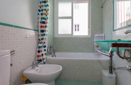 a bathroom with a sink and a toilet and a bath tub at Lightbooking Mazarredo San Fernando in San Fernando