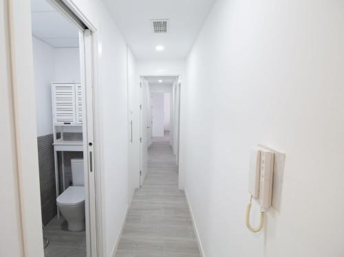 a corridor of a bathroom with a toilet and a mirror at Lightbooking Plaza de Toros Granada in Granada