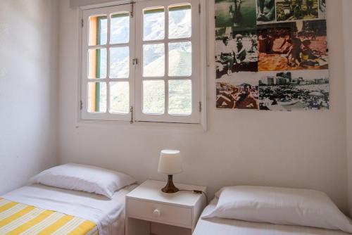 アガエテにあるCasa Carmen Agaete Vista al Marのベッドルーム1室(ベッド2台、窓付)