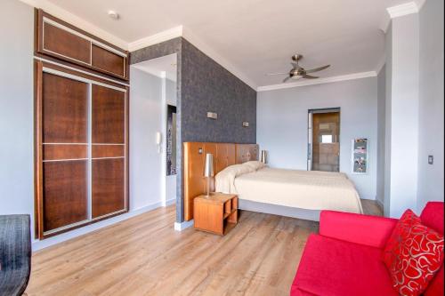1 dormitorio con 1 cama y 1 sofá rojo en Lightbooking Las Canteras Beach Sea View, en Las Palmas de Gran Canaria
