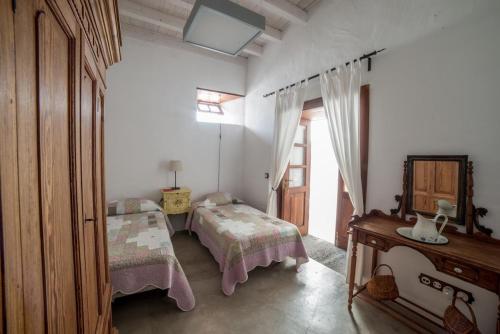 アリアにあるLightbooking Haría Lanzaroteのベッドルーム1室(ベッド2台、テーブル、窓付)
