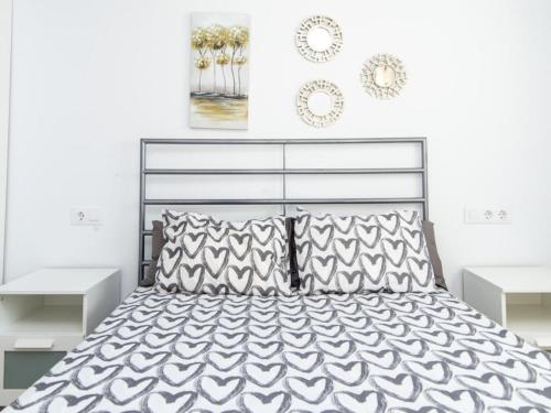 a bedroom with a black and white bed with pillows at Lightbooking Blanca Paloma Cádiz in El Puerto de Santa María