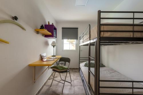 特爾德的住宿－Lightbooking Telde Lomo Salas Dey，宿舍间设有书桌和双层床。