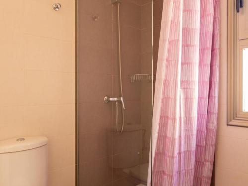 La salle de bains est pourvue d'une douche avec un rideau de douche rose. dans l'établissement Lightbooking Costa Antigua, à Costa de Antigua
