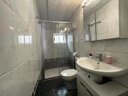 uma casa de banho com um lavatório, um WC e um chuveiro em Lightbooking Agua Garcia Tacoronte con terraza em Tacoronte