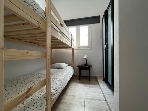 1 dormitorio con 2 literas y ventana en Lightbooking Agua Garcia Tacoronte con terraza, en Tacoronte