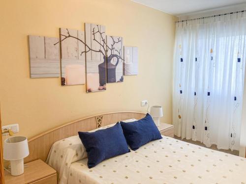 a bedroom with a bed with two blue pillows at Lightbooking Aloe Las Playitas Beach in Las Playitas