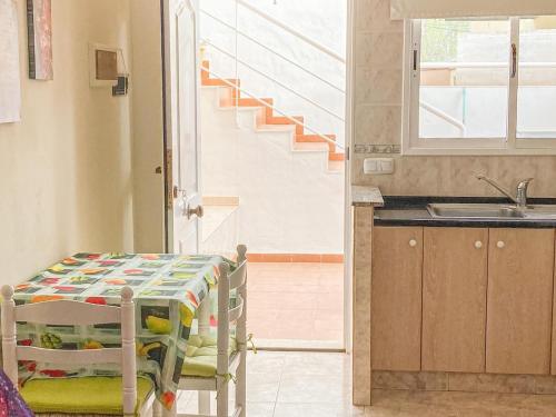 uma cozinha com uma mesa, um lavatório e uma escadaria em Lightbooking Aloe Las Playitas Beach em Las Playitas