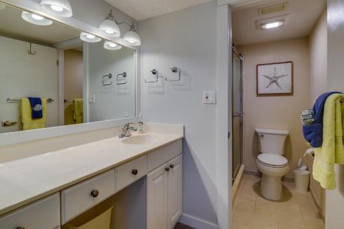 a bathroom with a sink and a toilet and a mirror at Sunny Ocean Village Condo with Community Pool! in Fort Pierce