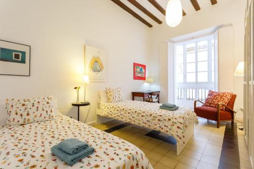 カディスにあるLightbooking Arboli Cadiz centro historicoのベッドルーム1室(ベッド2台、椅子付)