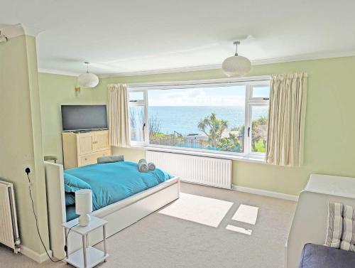 um quarto com uma cama e uma grande janela em East Creek home by the sea with pool em Dorchester