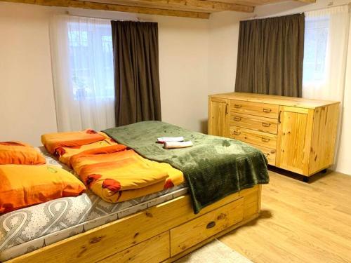 ein Schlafzimmer mit einem Bett und einer Holzkommode in der Unterkunft La-Marti, Idyllische Unterkunft mit Kamin in Bagdatʼi