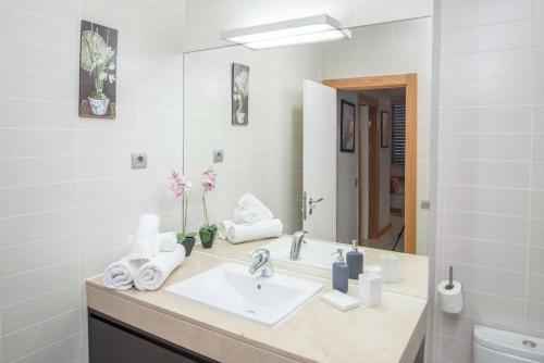 a bathroom with a sink and a mirror at Lightbooking piscina privada Salobre Golf in San Bartolomé