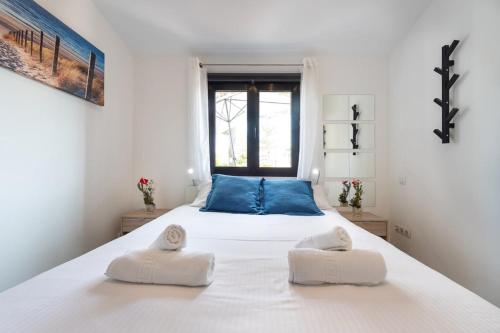 sypialnia z dużym białym łóżkiem i 2 ręcznikami w obiekcie Lightbooking Santa Barbara Playa del Ingles w mieście Maspalomas