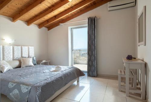 a bedroom with a bed and a large window at casamariatoroni in Toroni