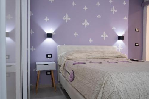 a bedroom with purple walls and a bed and a table at Appartamento Vale Mare Vista Canale in Chioggia