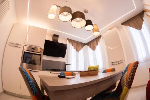 a kitchen with a table with chairs and a microwave at Appartamento Vale Mare Vista Canale in Chioggia