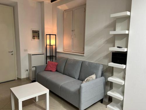 Sala de estar con sofá gris y mesa en Casa Maddy Pietrasanta, en Pietrasanta