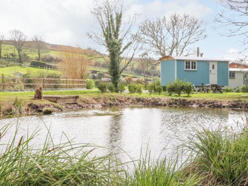 a house with a pond in front of it at Gwithian Shepherds Hut in Hayle