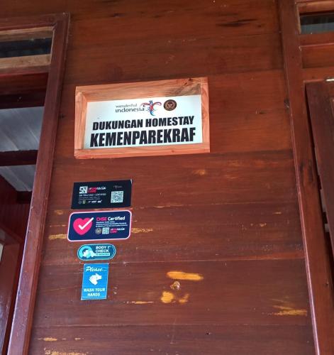 a sign on the front of a wooden door at Rumah Gadang Tokama, Simarasok in Baso