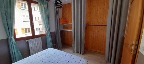 a small room with a bed and a window at La Turra in Lanslebourg-Mont-Cenis