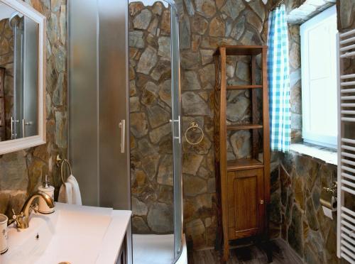 a bathroom with a shower with a stone wall at Horský apartmán Vrátna-Saška in Terchová