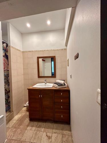 une salle de bain avec un lavabo et un miroir dans l'établissement UN MOMENT SUSPENDU, à Aix-en-Provence