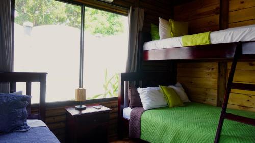 a bedroom with bunk beds in a wooden cabin at Bungalows Ballena in Uvita