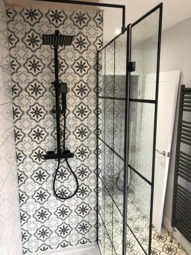 a shower in a bathroom with a tiled wall at Hattie's Cottage in Lincoln