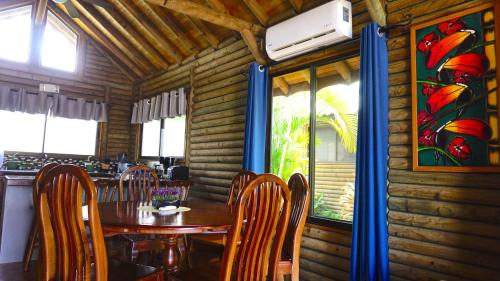 a dining room with a wooden table and chairs at Bungalows Ballena in Uvita