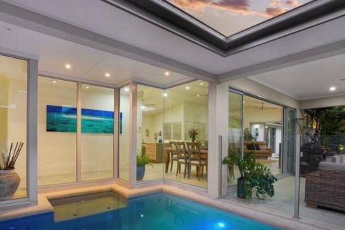 a house with a swimming pool and a living room at Tropical Villa Hideaway in Yorkeys Knob