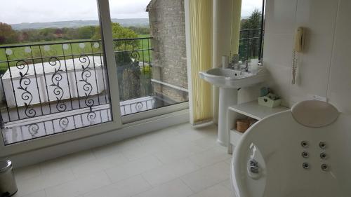 uma casa de banho com uma banheira, um lavatório e uma janela em The Wood Cottage em Scarborough